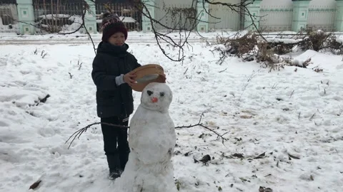 Boy decorates a snowman Stock Footage 112371767