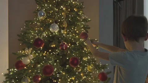 Boy Decorating Christmas Tree Close View Hanging Ornament Festive Family Home Stock Footage 344881538