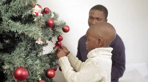 Boy decorating the christmas tree with his father Stock Footage 44299165