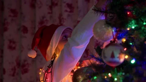 Boy decorating Christmas tree at home Stock Footage 219020056