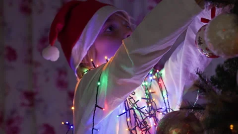 Boy decorating Christmas tree at home Video stock 219284328