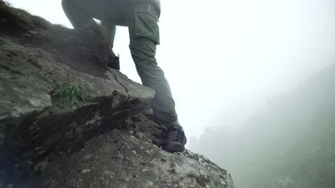 The boy descends from the mountains on the rocks. Stock Footage 214324599