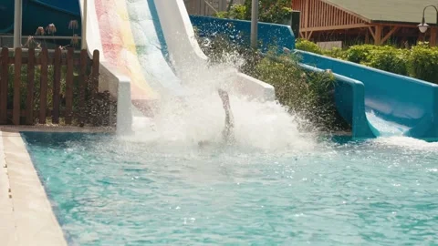 Boy descends from water slide into pool in water park Video stock 279054154