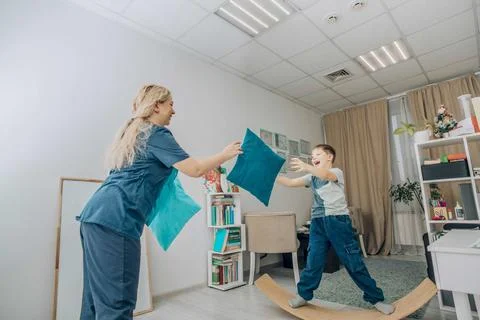 Boy developing motor skills and coordination by playing on a wooden wobble board Stock Photos