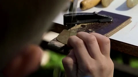Boy with a Diamond Saw Saws a Small Plate from a Larger Copper Plate Stock Footage 259432334