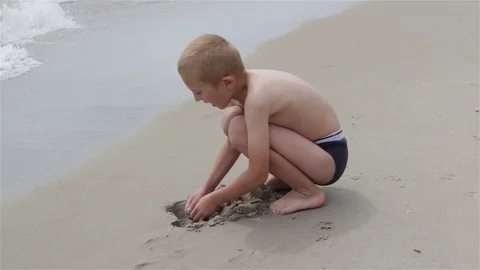 Boy digging a pit sea Stock Footage 71989167