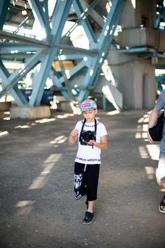 A boy with a digital camera walks through the object01.08.2022 Pskent, Uzbeki Stock Photos