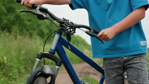 Boy diligently checks all different parts of his bicycle for damage, Young boy Stock Footage 324872745