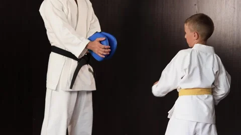 Boy diligently performs circular kicks on a blue exercise machine in motion Video stock 303434027