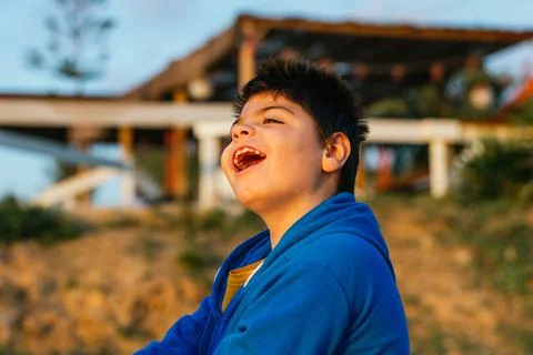 Boy with disabilities having fun and enjoying outdoors at sunset. Stock Photos