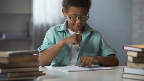 Boy with disability to learn reading and writing skills trying to concentrate Stock Footage 80691652