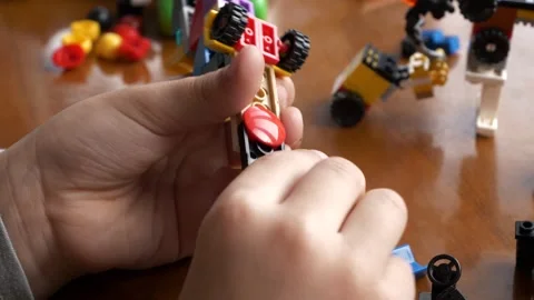 A boy is disassembling Toy Vehicle made of construction Building Blocks at Home Stock-Footage 264976799