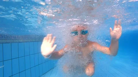 The boy dives into the pool and swims underwater. Slow Motion - Perfect for Stock Footage 170290740