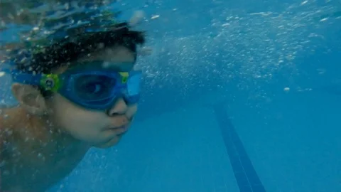Boy dives in to swimming pool Stock Footage 88302897