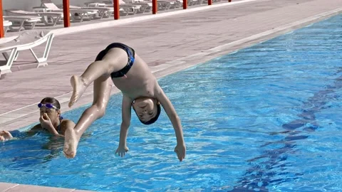 A Boy Diving in Blue Pool Water Stock Footage 202676924