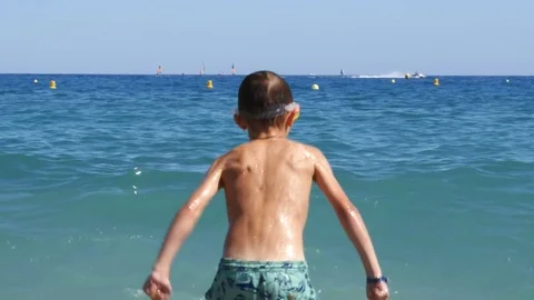 A boy in diving mask having fun in sea waves - 4K Stock Footage 80232025