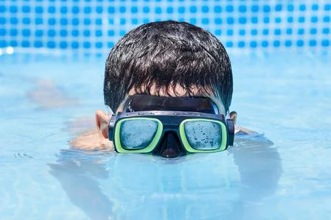 A boy in diving mask having fun in the swimming pool Stock Photos