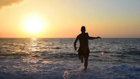 Boy diving into the sea with sunset - slowmotion Stock Footage 82569017