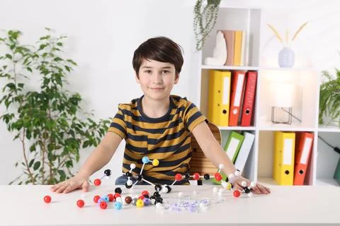 Boy with DNA structure model at desk indoors 스톡 사진
