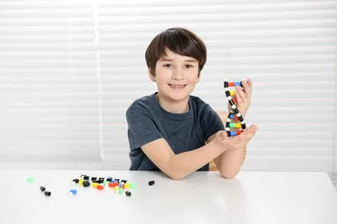 Boy with DNA structure model at desk indoors 스톡 사진