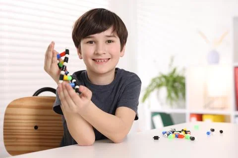 Boy with DNA structure model at desk indoors 스톡 사진