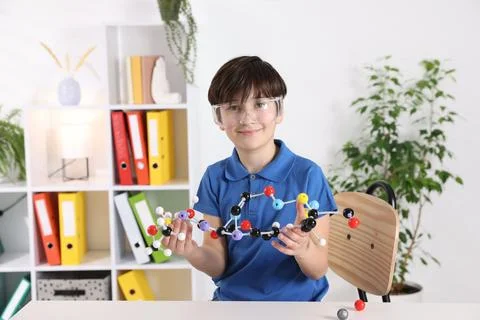 Boy with DNA structure model at desk indoors 스톡 사진