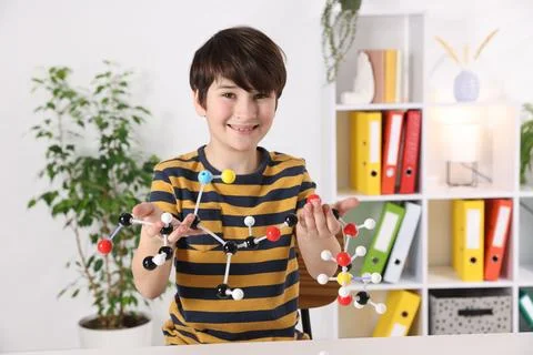 Boy with DNA structure model at desk indoors Stock Photos