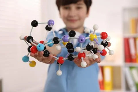 Boy with DNA structure model indoors, selective focus 스톡 사진