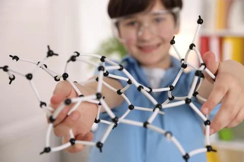 Boy with DNA structure model indoors, selective focus 스톡 사진