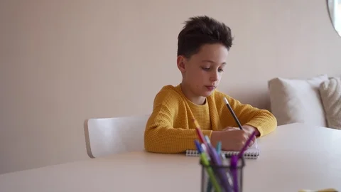 Boy do school homework, writes a ballpoint pen in a notebook. 스톡 동영상 104239354