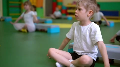 The boy does breathing exercises in the gymnastics group. Stock Footage 204842210