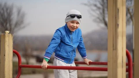 The boy does exercises on parallel bars in the fresh air in the park Foto stock