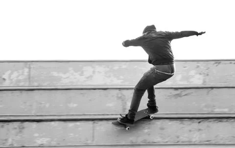 Boy does a grind trick with skateboard Stock Photos