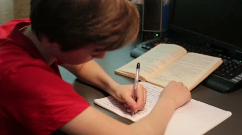 Boy does lessons, writes in a notebook Video stock 50965793