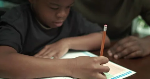 Boy does math homework with Smiling Father Stock Footage 131685358
