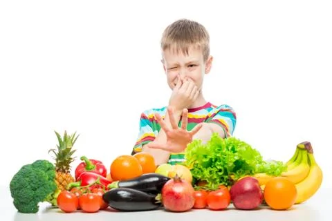 The boy does not like vegetables and fruits, disgust for food concept photo i Stock Photos