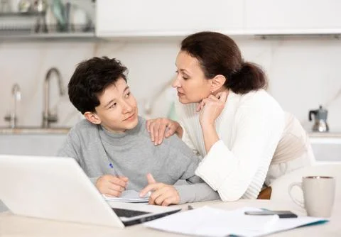 Boy does school homework with his mother and solves mathematical problems in Foto stock