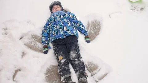 Boy doing an angel on the snow Stock Footage 85299011