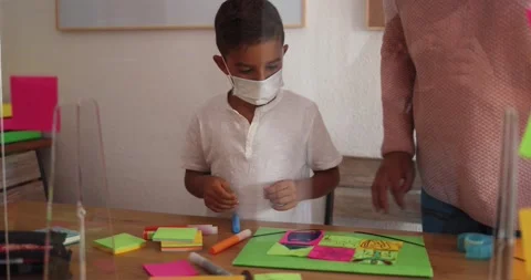 Boy doing collage in preschool classroom wearing face protective mask Stock Footage 141051135