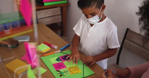 Boy doing collage in preschool classroom wearing face protective mask Stock Footage 141051136