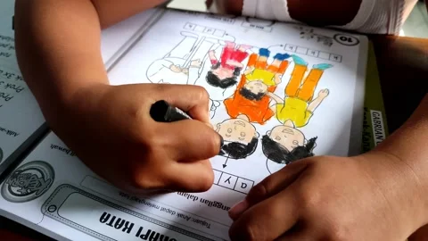 Boy doing coloring task in drawing book from school full of fun Stock Footage 158881589