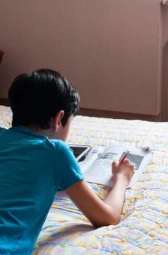 Boy doing his homework using digital tablet. Stock Photos