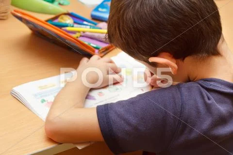 Boy doing homework with color pencil, painting fruits Stock Photos