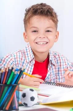 Boy doing homework at desk Stock Photos