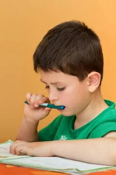 Boy doing homework from school in workbook boy thinking on homework from s... Stock Photos