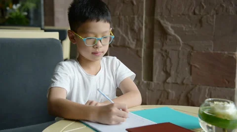 Boy doing homework on table Stock Footage 67580298