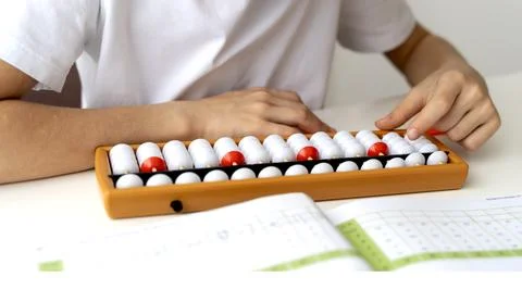 Boy doing mental arithmetic on abacus 스톡 사진