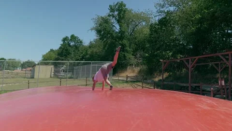 A Boy is doing Somersaults on a Trampoline Slow Motion Stock-Footage 345595944