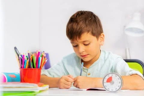 Boy doing writing exercise on time at class Stock Photos