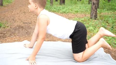 Boy doing yoga in the woods Stock Footage 122120590